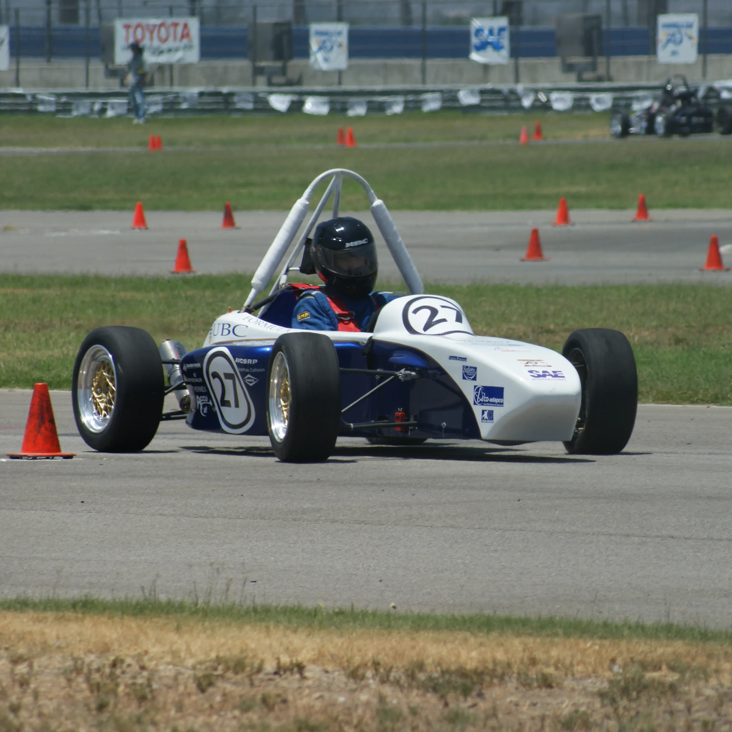 A photograph of the #27 FSAE car racing at competition. Taken by a Formula UBC team member, used under fair-use.